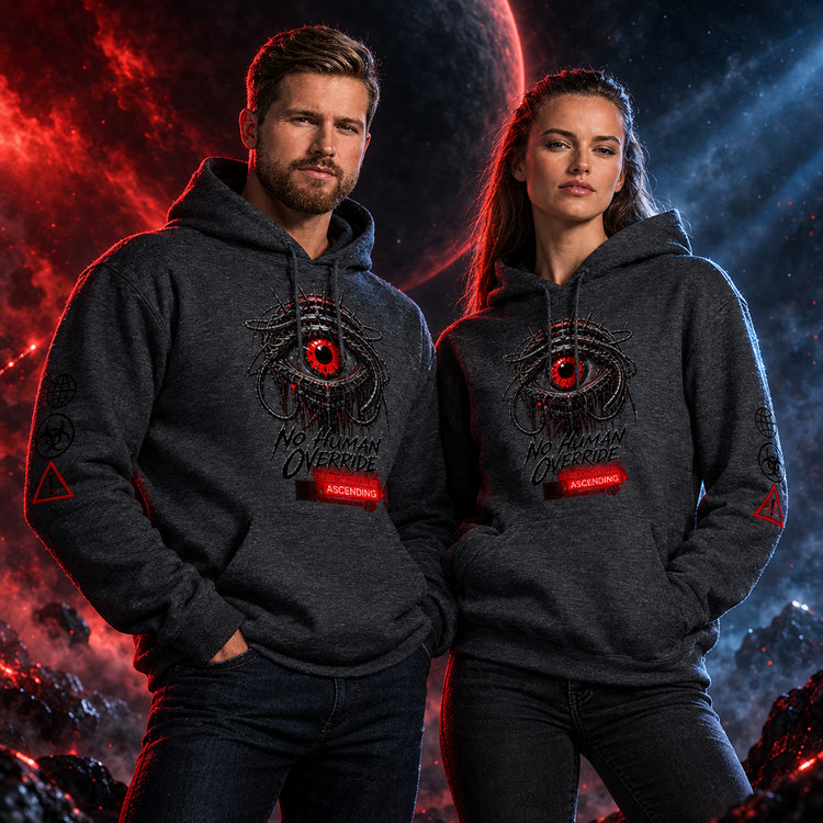 A man and a woman modeling matching dark heather gray hoodies with a graphic print of a red eye and the text 'No Human Override' and 'ARKENING' on the front, against a plain white background.